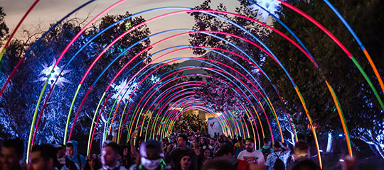 Headliners walking under a colorful archway