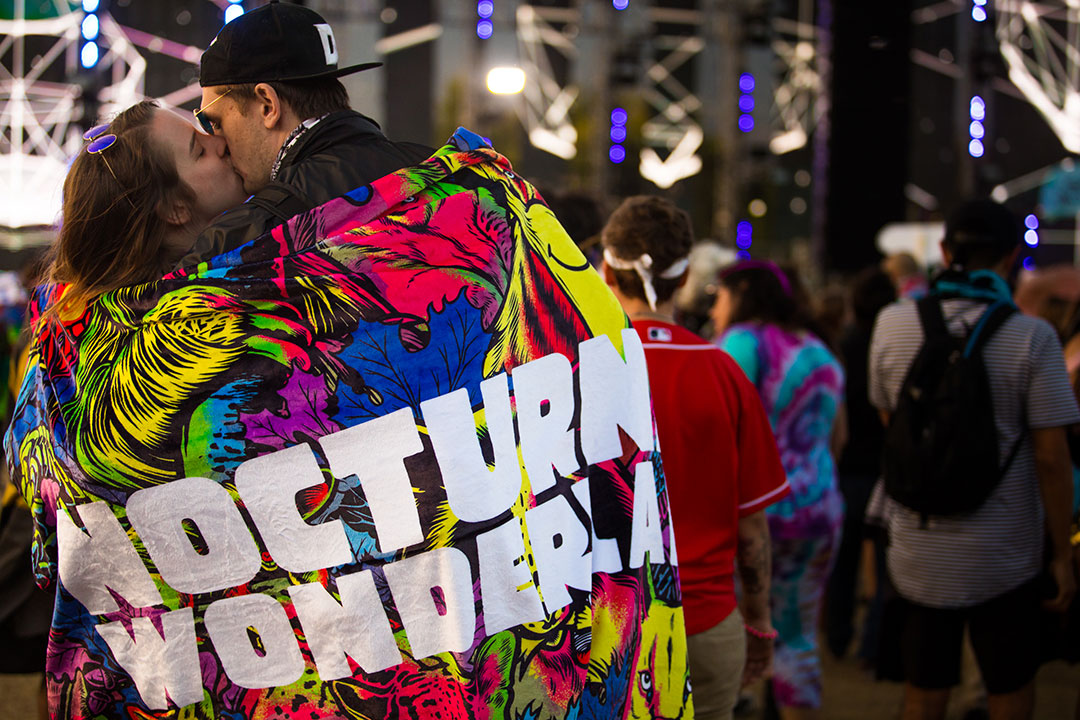 A couple wrapped in a Nocturnal Wonderland flag