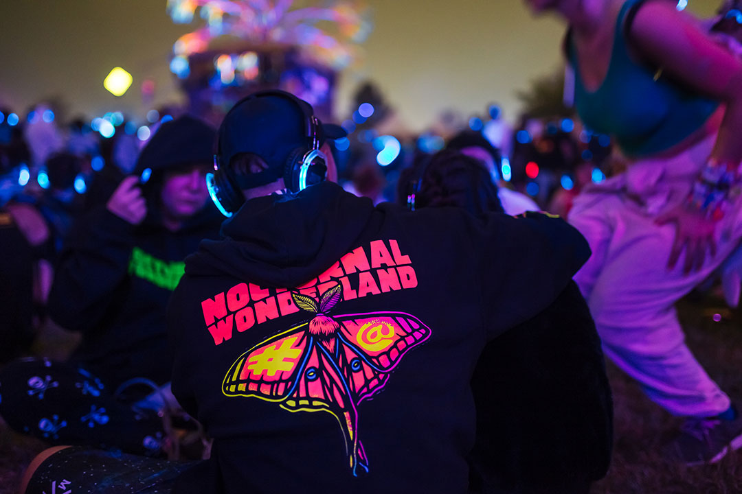 A guy in a Nocturnal Wonderland hoodie at the silent disco