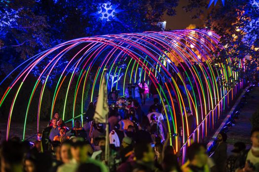Headliners walk under a colorful archway