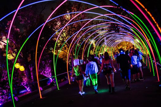 Headliners walk under a glowing archway