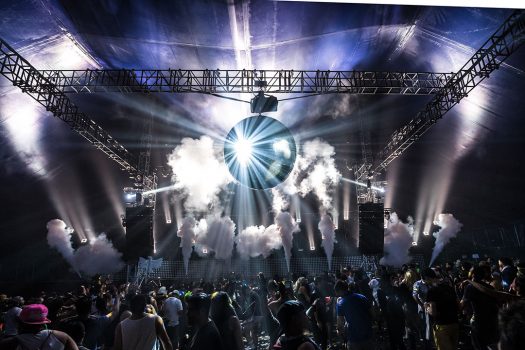 A disco ball shines above the crowd