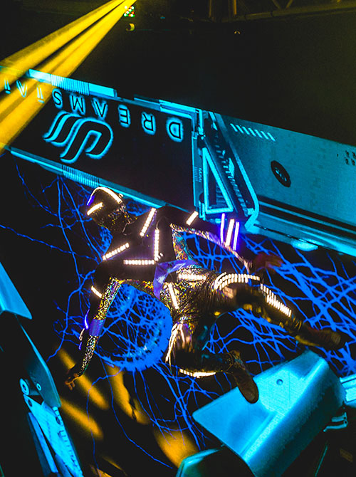 A futuristic performer jumps in the air
