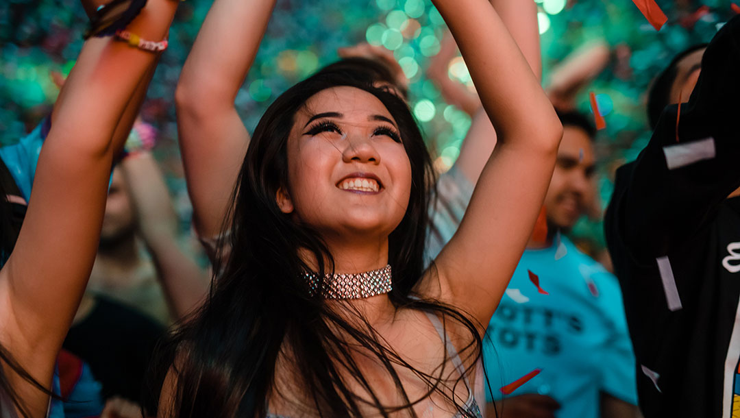 A smiling girl with her hands in the air