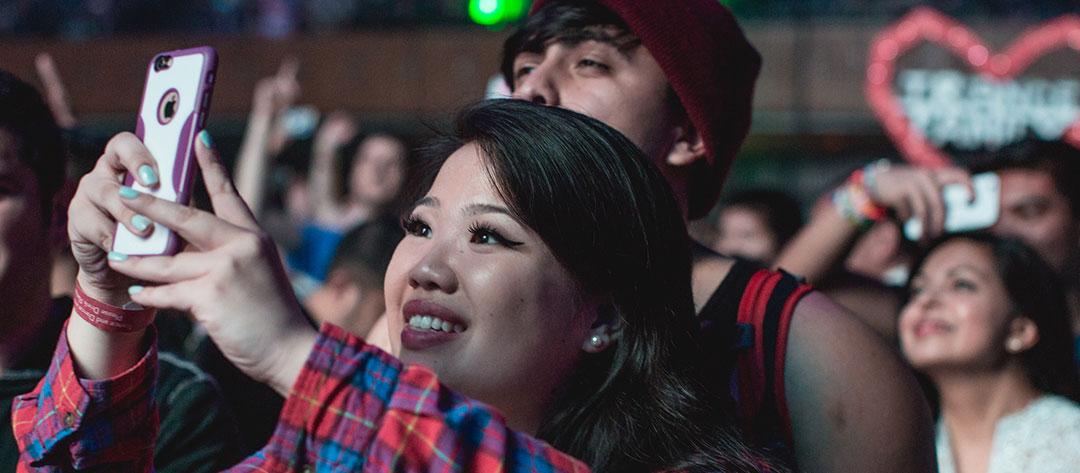A Headliner takes a photo with her phone