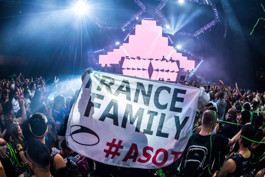 Headliners hold up a "Trance Family" flag