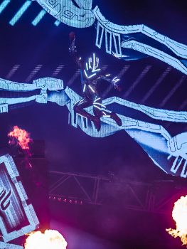 A futuristic performer jumps in the air