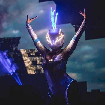 A futuristic performer in a glowing helmet