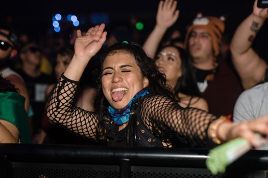 A girl in the front row dancing with her tongue out