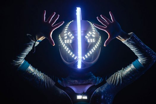 A performer in a glowing helmet