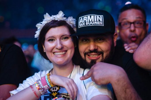 A woman in a flower crown with a man in an Armin van Buuren hat