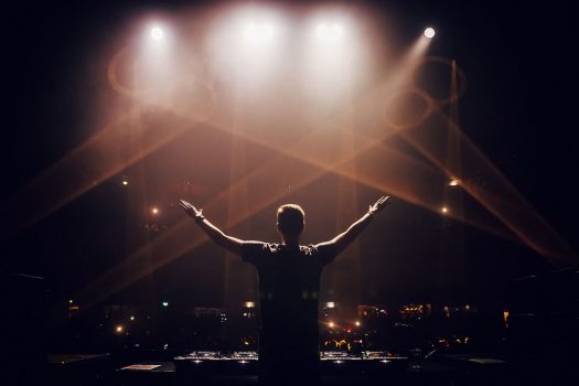 A DJ with his hands in the air