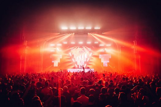 Red lights emanate from the stage