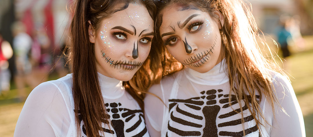 Two women in skeleton costumes