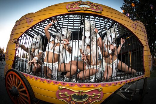 Masked performers in a cage