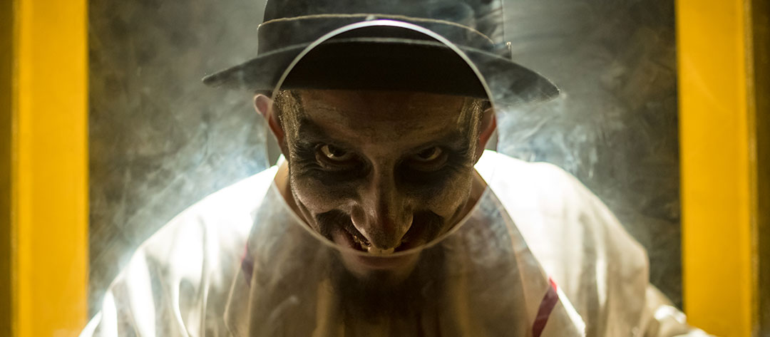 A creepy guy peers through a hole