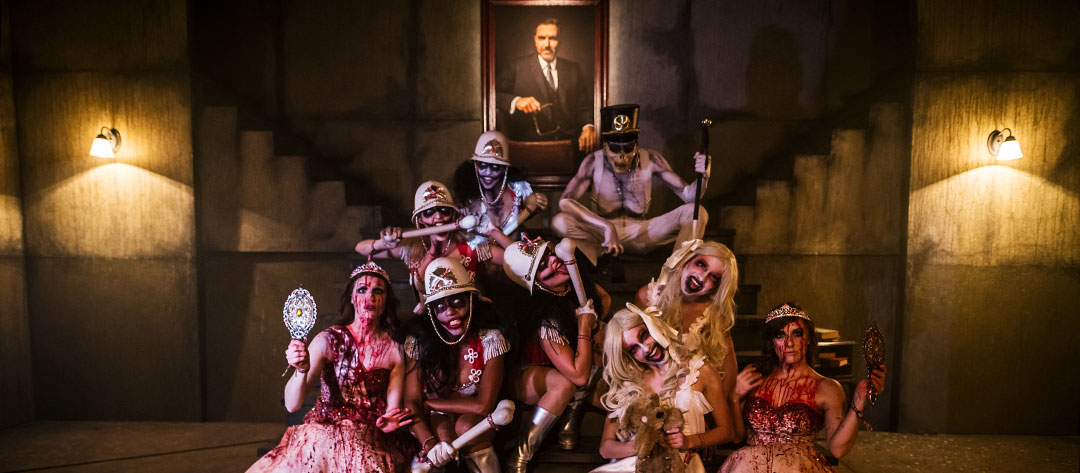 Performers pose in front of a portrait of Pasquale Rotella