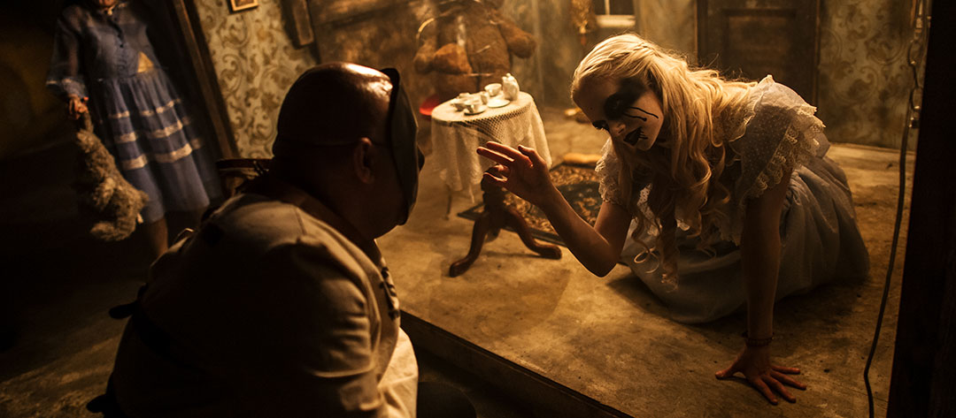 Alice greets a masked inmate