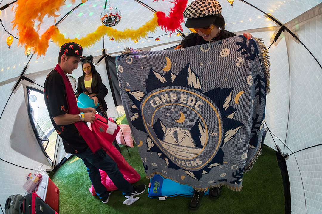 A Headliner holds up a "Camp EDC" blanket