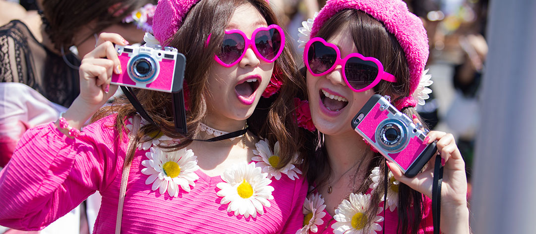 Two girls with heart sunglasses and pink cameras