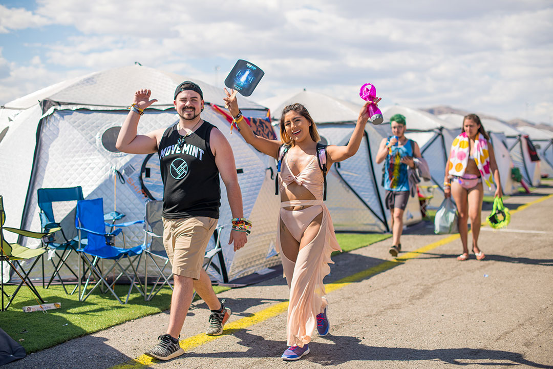 Two people walking by the tents