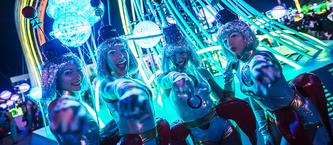 Costumed performers point to the camera