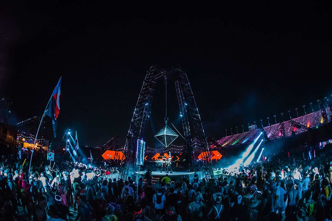 A diamond-shaped structure hangs above the crowd