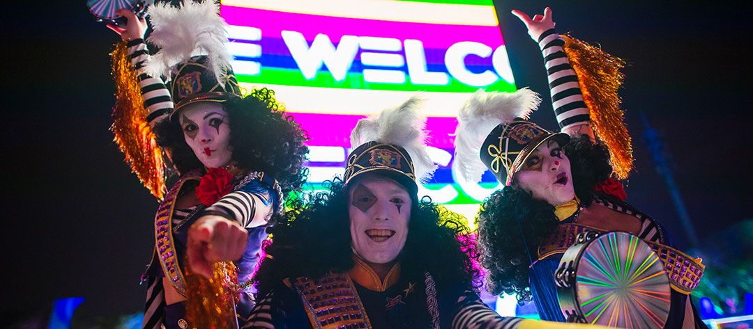 Performers in front of the Welcome sign