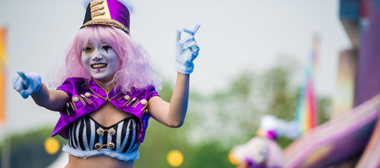 A clown smiles and points