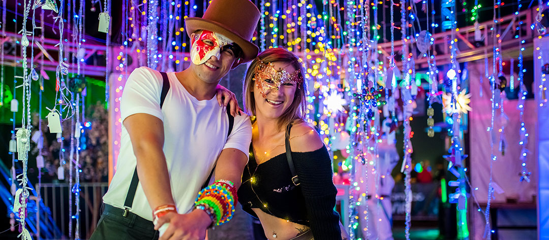 A man and woman in front of sparkly lights