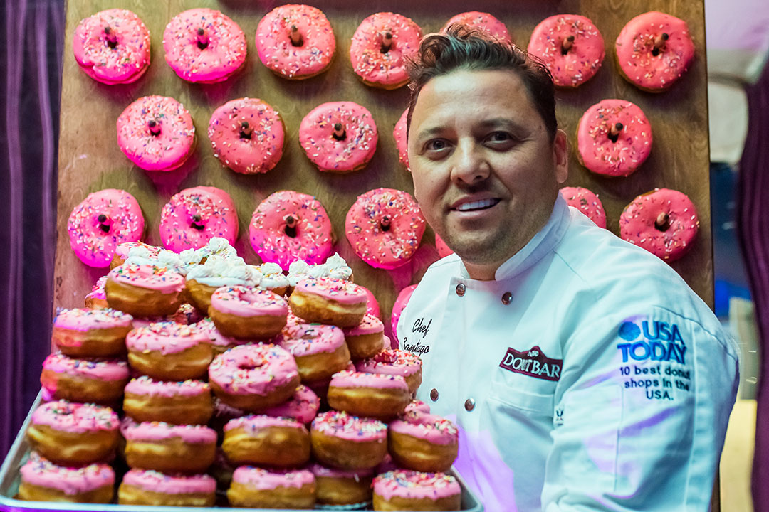 A man with lots of pink donuts