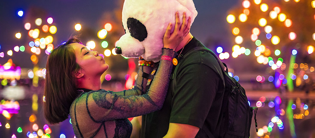 A woman kissing a man in a panda costume