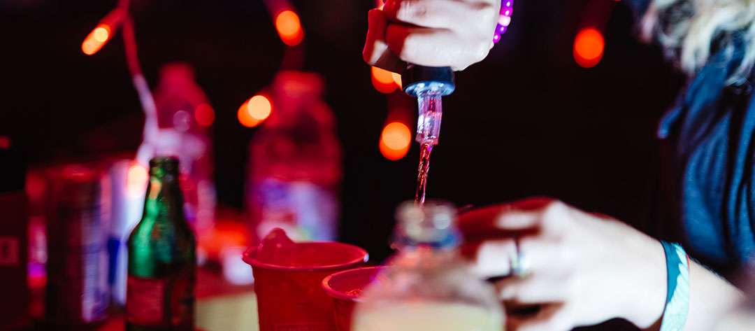 A bartender pours liquor