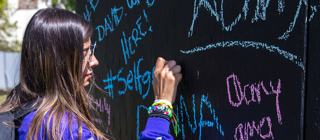 A woman writing on the unity wall