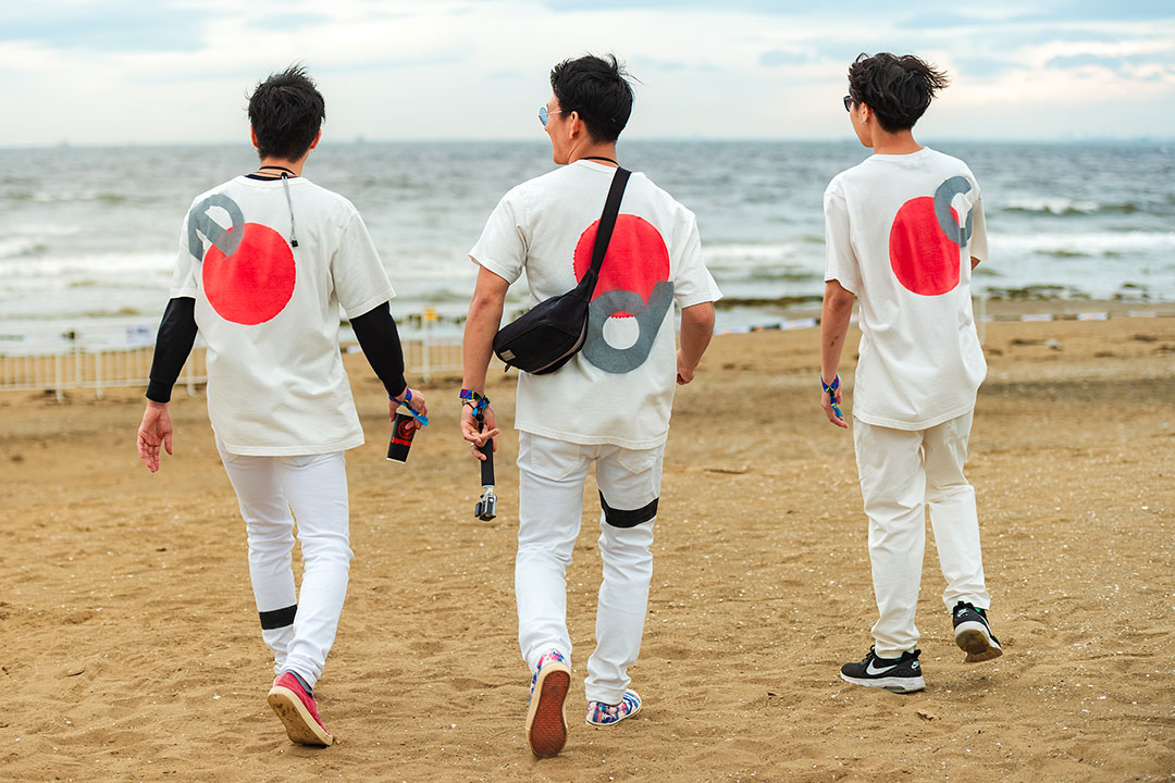 Three guys walk on the beach