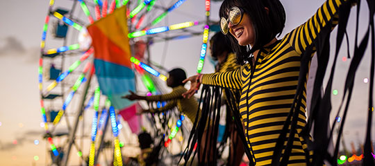Costumed performers with a Ferris wheel in the background