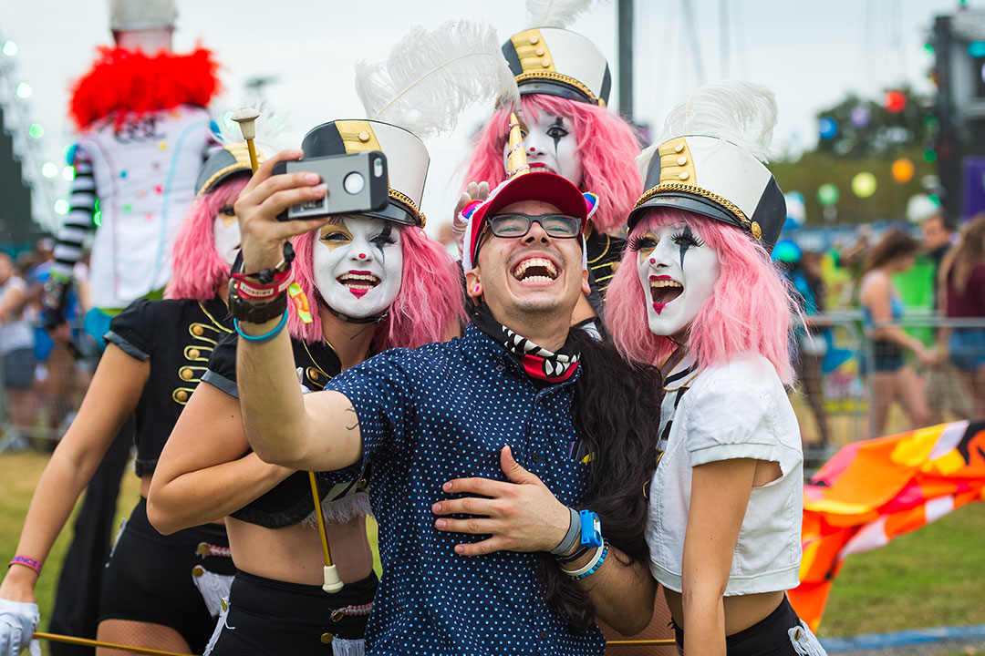 Costumed performers pose for a selfie with a happy Headliner