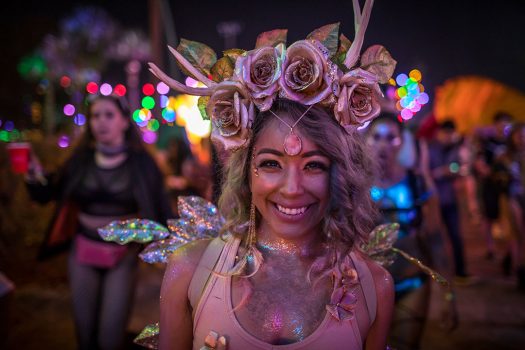 A Headliner with a flower crown and glitter body paint