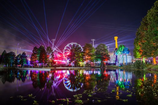 Lasers and a Ferris wheel seen from across a pond