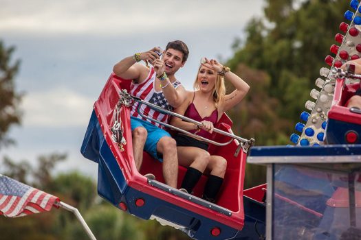 Two people take a selfie on a carnival ride