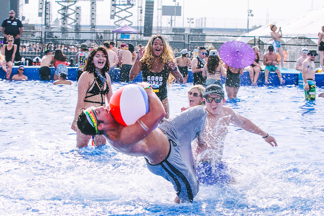 Friends play with a beach ball in the VIP pool